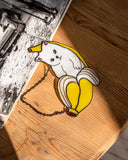Decorative sticker of a dog with a banana on a wooden surface