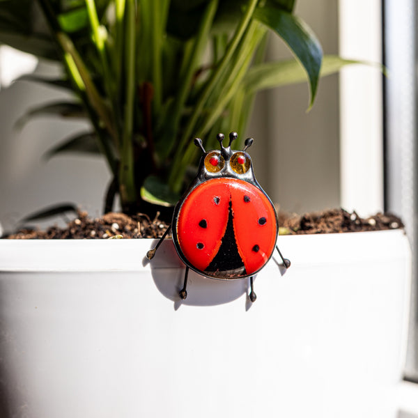 Decorative ladybug on a plant pot with a blurred background