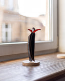 Abstract sculpture on a wooden base in front of a window