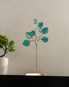 Decorative glass plant on a table with a plain background