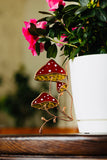 Decorative mushroom-shaped ornament on a wooden surface with flowers in the background