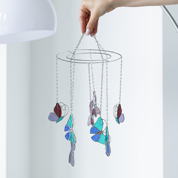 Butterfly stained glass suncatcher in soft pink with floral accents, handmade from high-quality glass, perfect for windows, walls, and as a gift for nature lovers.