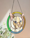 Stained glass panel of a cat held by a hand against a neutral background