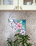 Stained glass panel with floral design hanging on a wall