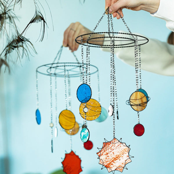 Colorful hanging mobile with celestial designs against a light blue background