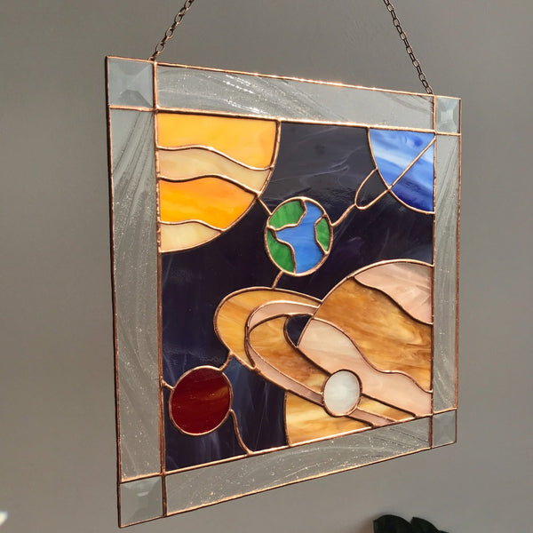 Stained glass panel with abstract design on a plain wall
