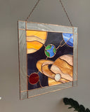 Stained glass panel with abstract design on a plain wall
